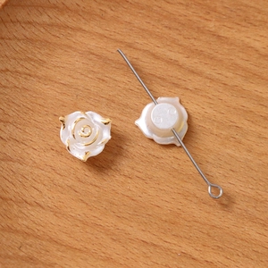 Vue détaillée de perles roses blanches aux bords dorés avec trous de filetage pré-percés