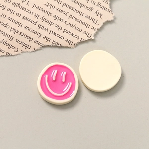 Macro view of cute resin smiley face charms in pink and white for DIY crafts