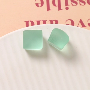 Gros plan sur des pendentifs carrés en résine givrée vert menthe pour bijoux DIY