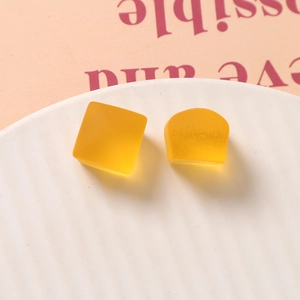 Vue macro de pièces en résine géométriques jaune mat translucide carrées et en arche