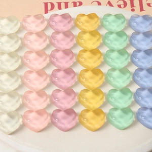 Macro detail of assorted pastel frosted resin hearts arranged on a display tray for DIY