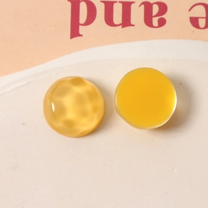 Macro shot of 16mm yellow resin geometric charms with water ripple and smooth texture