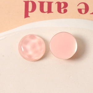 Close-up of 16mm light pink resin accessories with hammered and smooth textures for DIY crafts