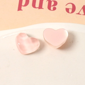Detailed view of two light pink resin heart charms with ripple texture for DIY accessories