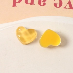 Macro detail of amber resin heart charms with ripple texture and smooth jelly finish