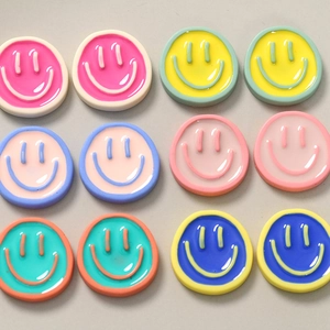 Flat lay of colorful resin smiley face charms for DIY crafts and phone case accessories
