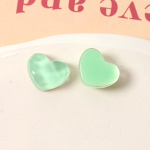 Detailed macro view of mint green resin heart charms with unique water ripple textures