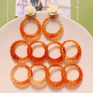 Macro view of amber resin twisted rings and rose petal earring components for DIY crafts