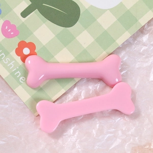 Close-up of pink glossy resin bone charms for DIY hair clips and jewelry making accessories