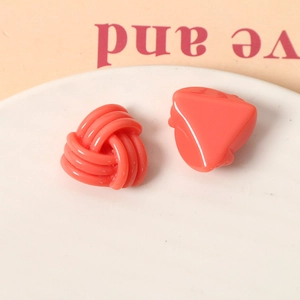Détail d'accessoires en résine rose corail avec nœud triangulaire et forme de cœur