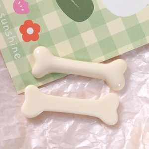 Macro detail of two cream bone resin charms for DIY jewelry and hair accessories