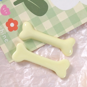 Detail of glossy cream yellow bone-shaped resin charms for DIY hairpins and accessories