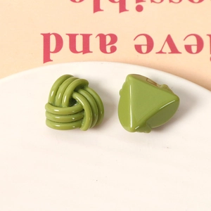 Détail macro de boucles d'oreilles en résine vert olive avec nœud tressé et triangle