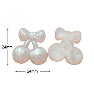 Macro view of cherry-shaped resin charms with pink glitter and bow details for DIY craft