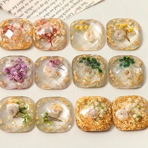Detail of 12 geometric resin charms with dried flowers, shell fragments, and gold foil