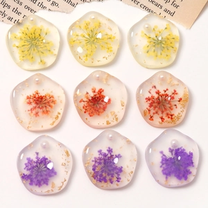 Detailansicht handgefertigter Harz-Blumenanhänger mit Goldfolie und Perlen für DIY-Schmuck