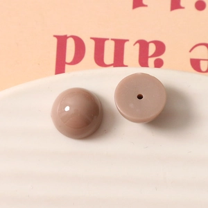 Détail de perles demi-rondes en résine de 12mm avec dos plat et trou de couture central