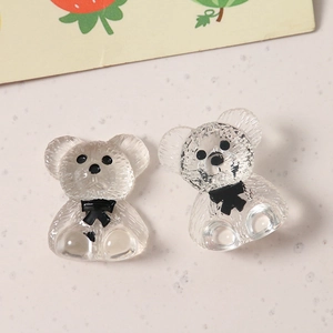 Macro shot of cute transparent resin bears with black bows for DIY jewelry making