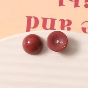 Détail de perles demi-rondes en résine rouge foncé 12mm avec surface lisse et trou