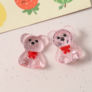 Close-up of cute pink translucent resin bears with red bow ties for DIY craft accessories