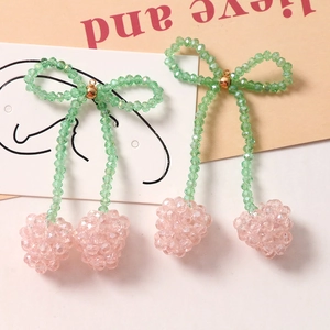 Nahaufnahme der handgefertigten rosa Kristallkirsche mit Schleife und Goldring
