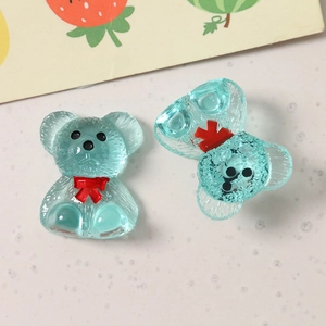 Close-up of light blue resin bear charms with red bowties and textured matte finish