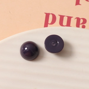 Gros plan macro de cabochons en résine violet foncé de 12 mm sur un plateau