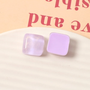 Dettaglio macro di orecchini a lobo quadrati in resina viola da 15mm con brillantini