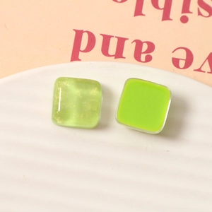 Dettaglio orecchini quadrati in resina da 15 mm con glitter dorati e trama a effetto onda