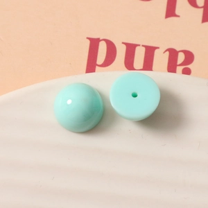Vue macro de demi-perles en résine vert menthe 12mm avec base plate et détails du trou