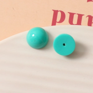 Vue macro de perles en résine sarcelle de 12 mm avec dos plat pour bijoux artisanaux