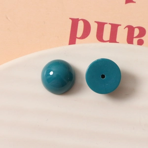 Vue macro d'une perle en résine bleu sarcelle 12mm avec dos plat pour loisirs créatifs