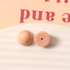 Détail macro de cabochons en résine rose pêche de 12 mm au fini porcelaine lisse