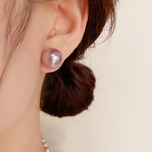 Macro detail of elegant 12mm light purple pearl stud earring on model for jewelry display