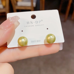 Detail of elegant gold pearl stud earrings on an S925 silver needle display card