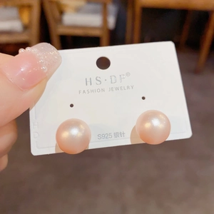 Close-up of pink 10mm pearl earrings with S925 silver needles on a display card