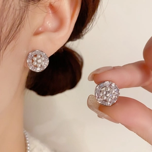 Primer plano de pendientes de perlas plateadas con circonitas en la oreja del modelo