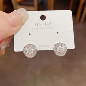 Primer plano de pendientes de lujo con agujas de plata S925 y diseño de pétalos de perla