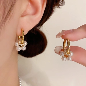 Detailed macro view of pearl flower drop earrings with sparkling rhinestone centers