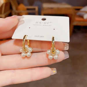 Detail of flower pearl drop earrings featuring S925 silver needle on a display card
