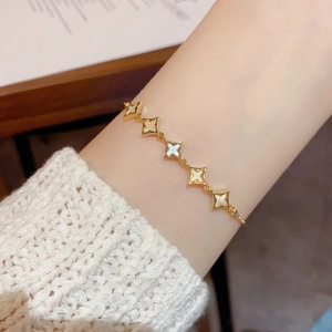 Close-up of a gold star bracelet featuring iridescent shell inlays and a delicate chain