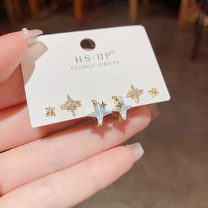 Detailaufnahme eines sechsteiligen Sets goldener Sternohrringe mit Zirkonia-Steinen