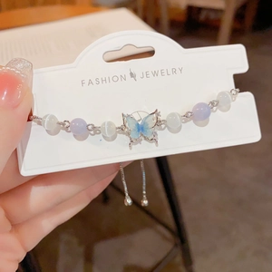 Detail of adjustable butterfly bracelet with cat-eye beads and drawstring closure
