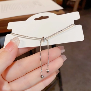 Detail of adjustable silver box chain with sliding toggle clasp and ball charms
