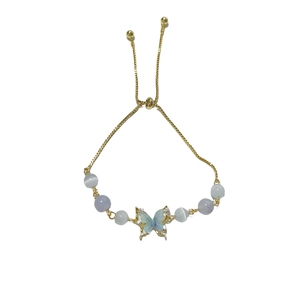 Adjustable golden bracelet with butterfly cat eye beads and zircon stones on white background