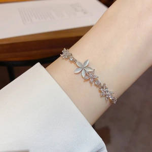 Detail of silver flower bracelet with cat eye stones and zircons worn on the wrist