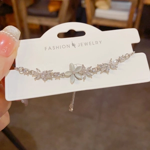 Silver flower bracelet with zircon and cat eye stone on a jewelry display card