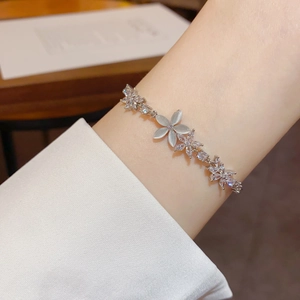 Elegant silver flower bracelet with cat eye stones and sparkling zircons on female wrist