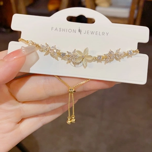 Close-up of golden floral bracelet featuring marquise crystals and cat eye stone details