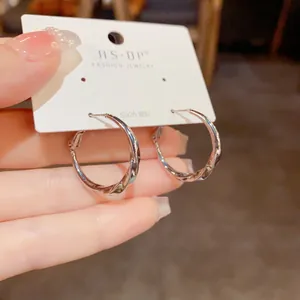 Détail de la boucle d'oreille créole torsadée argentée avec tige en argent S925